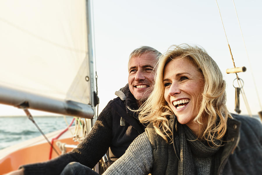Mature couple on sailing boat, smiling Photograph by Sporrer/Rupp