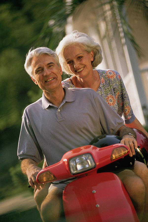 Mature couple on scooter Photograph by Comstock
