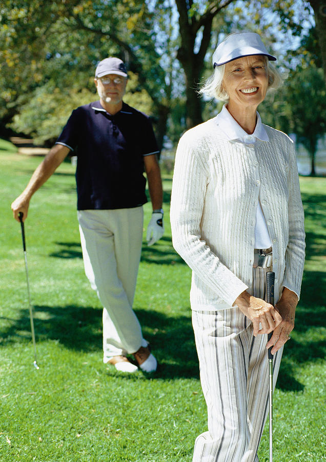 Mature couple playing golf Photograph by Vincent Hazat