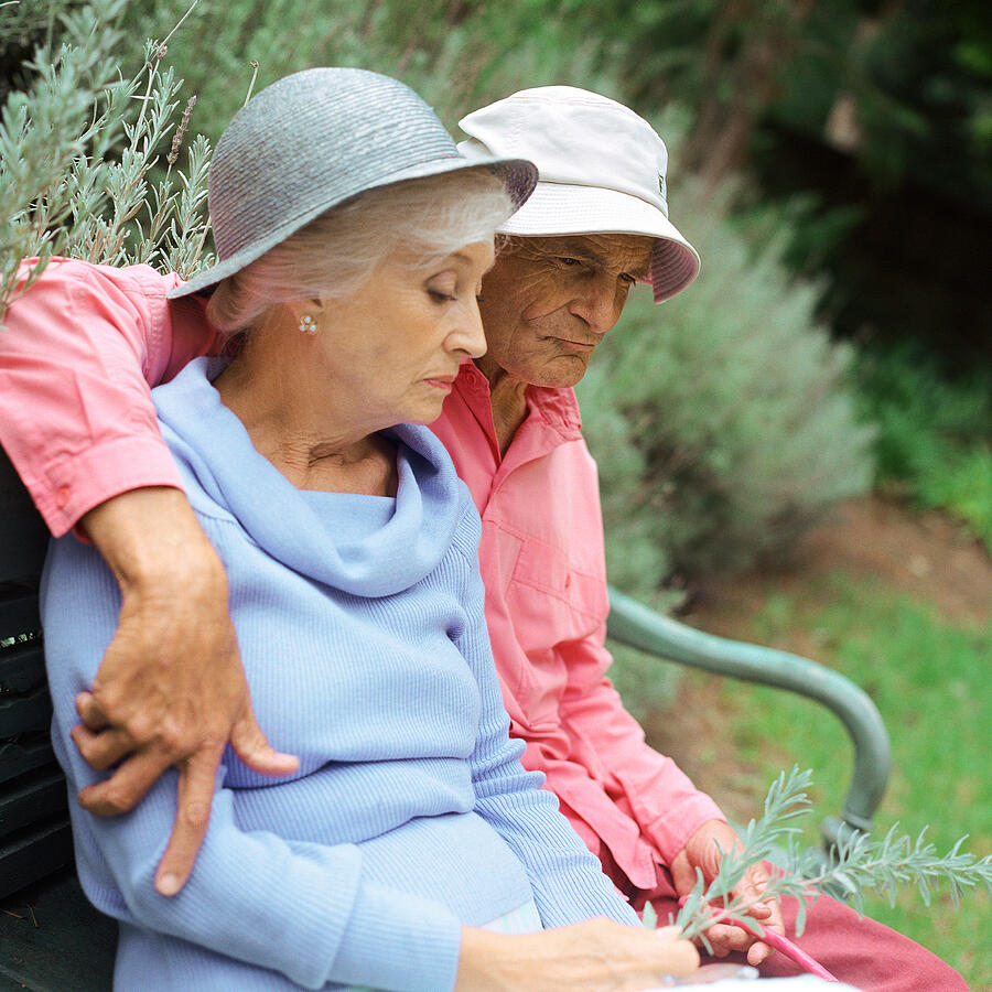 Mature couple sitting on bench outside Photograph by Patrick Sheandell OCarroll