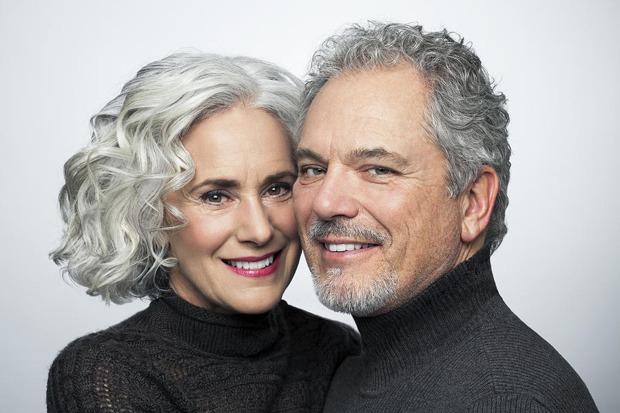 Mature couple smiling for camera, portrait. Photograph by Andreas Kuehn