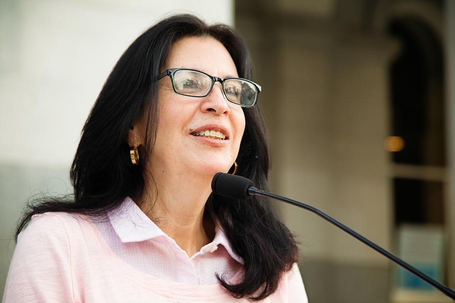 Mature Latina woman smiling at crowd during speech over microphone Photograph by NicolasMcComber