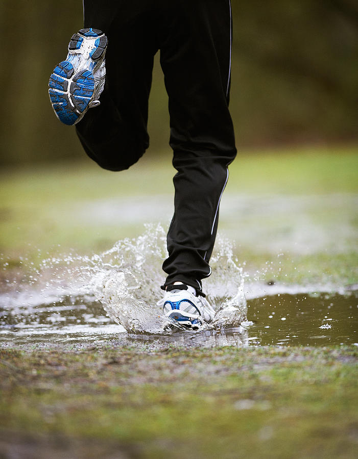 Mature Male Running Through Puddle Photograph by Mike Harrington