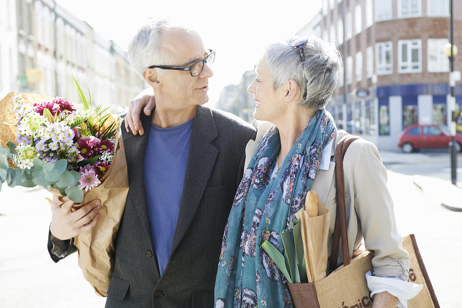 Mature Man And Woman On Street With Shopping Photograph by Tara Moore