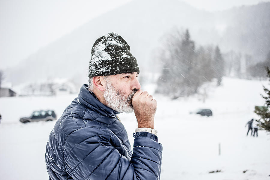 Mature Man blowing in his Hands on a cold Winter day Photograph by CasarsaGuru