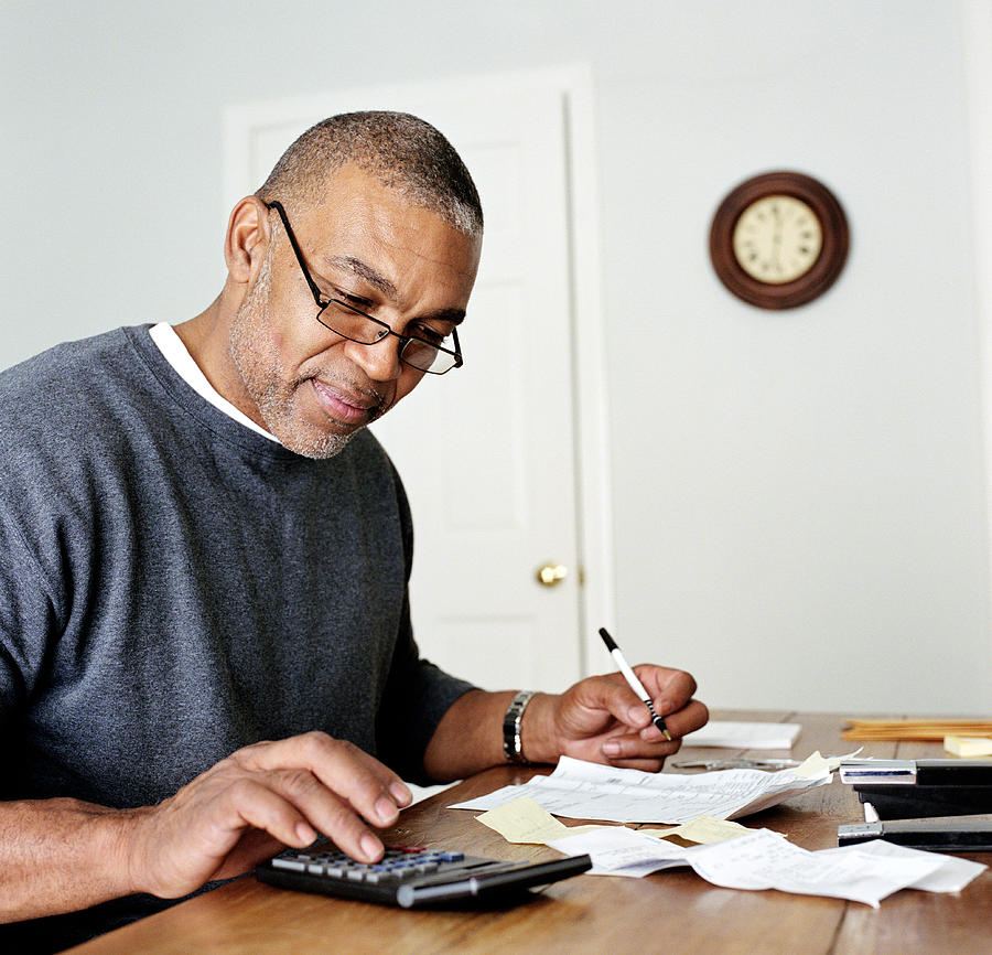 Mature man doing finances in home office Photograph by Siri Stafford