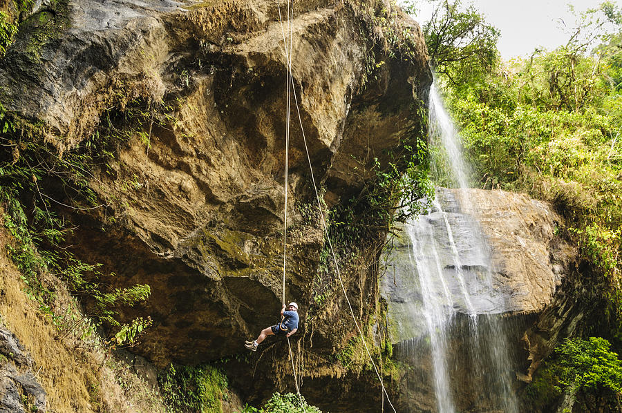 Mature man rappeling next to a waterfall Photograph by OGphoto