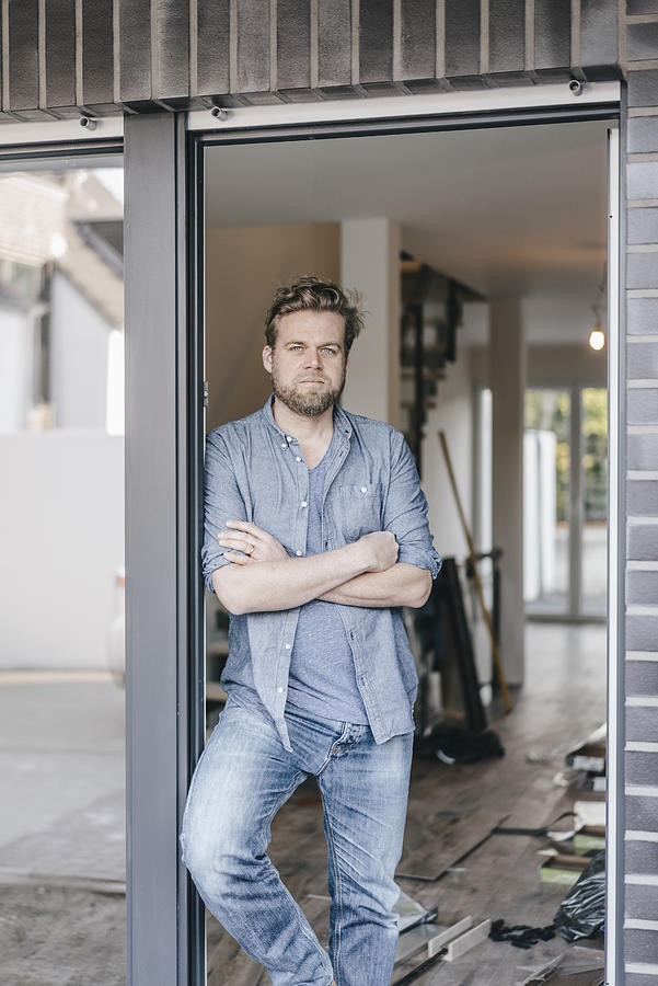 Mature man standing in door of his new home Photograph by Westend61