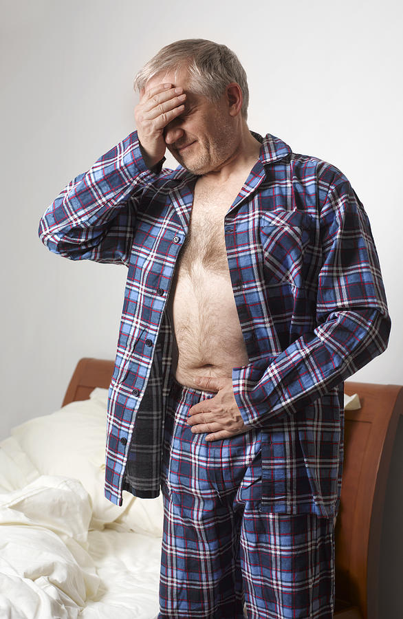Mature man suffering with stomach pain Photograph by Peter Dazeley