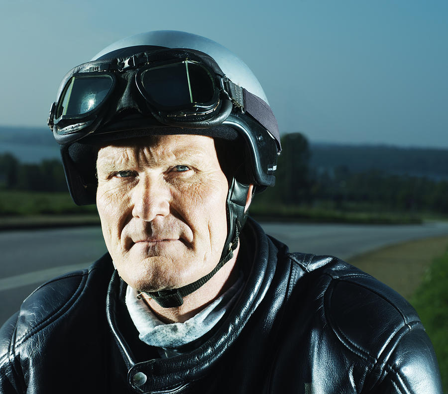 Mature man wearing motorcycle helmet, portrait Photograph by Henrik Sorensen