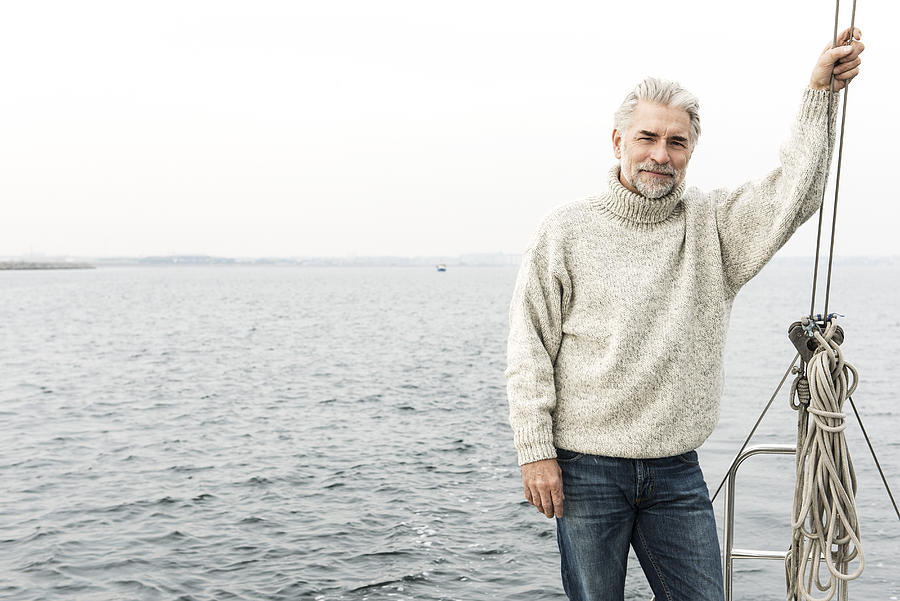 Mature man with grey hair on sailingboat Photograph by Robin Skjoldborg