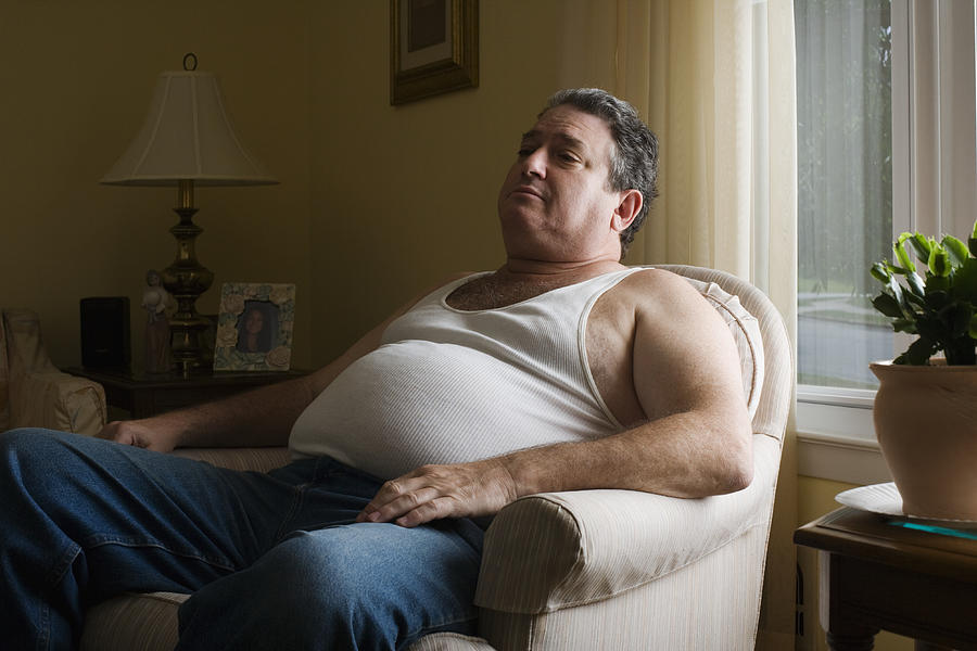 Mature overweight man sitting in armchair Photograph by Michael Greenberg