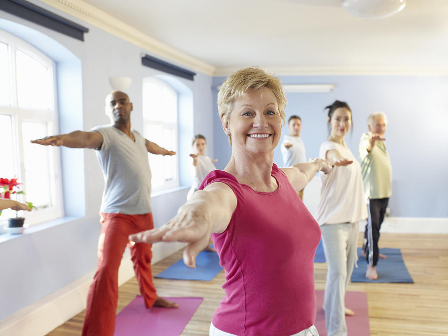 Mature woman at front of exercise class Photograph by Dougal Waters