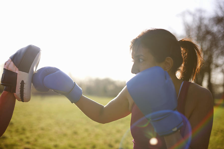 Mature woman boxer training in field Photograph by Peter Muller