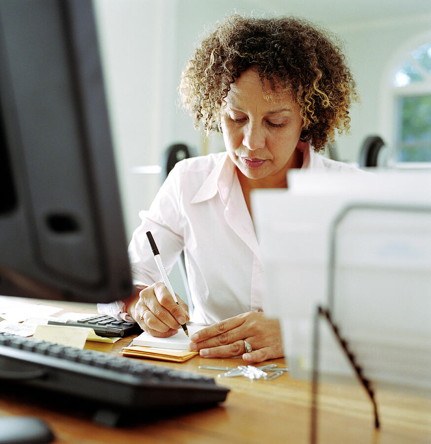 Mature woman doing finances in home office Photograph by Siri Stafford