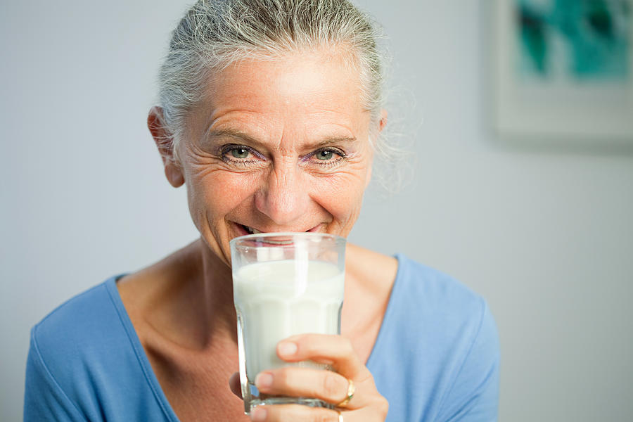 Mature woman drinking milk Photograph by Image Source