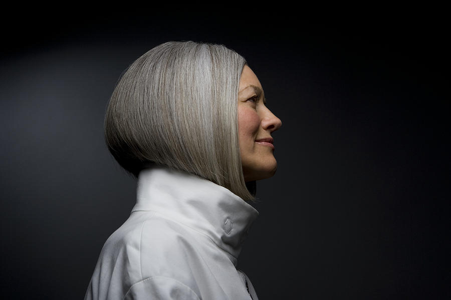 Mature woman smiling, side view, close-up Photograph by Ralf Nau