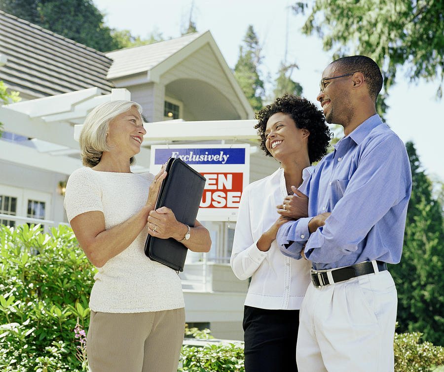 Mature woman standing with couple in front of Open House sign Photograph by Andersen Ross