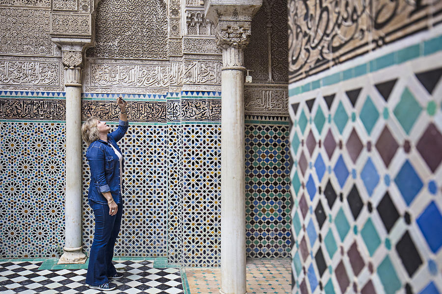 Mature woman visiting Attarine Madrasa in Fez Photograph by Xavierarnau
