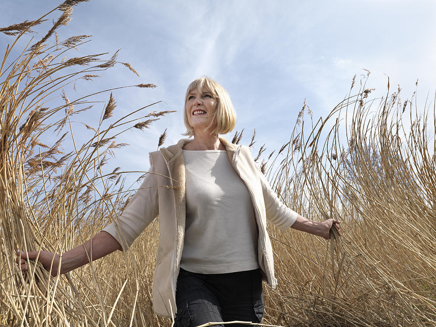 Mature Woman Walking In Reeds Photograph by Colin Hawkins