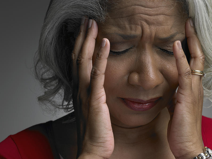 Mature woman with head in hands and eyes closed, close-up Photograph by Christopher Robbins