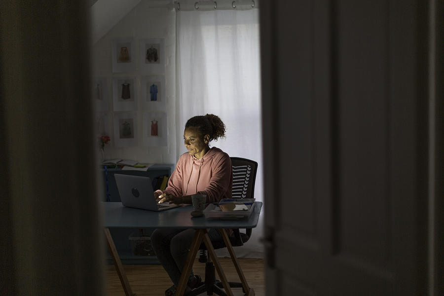 Mature woman working from home on a video call in the evening Photograph by Alistair Berg