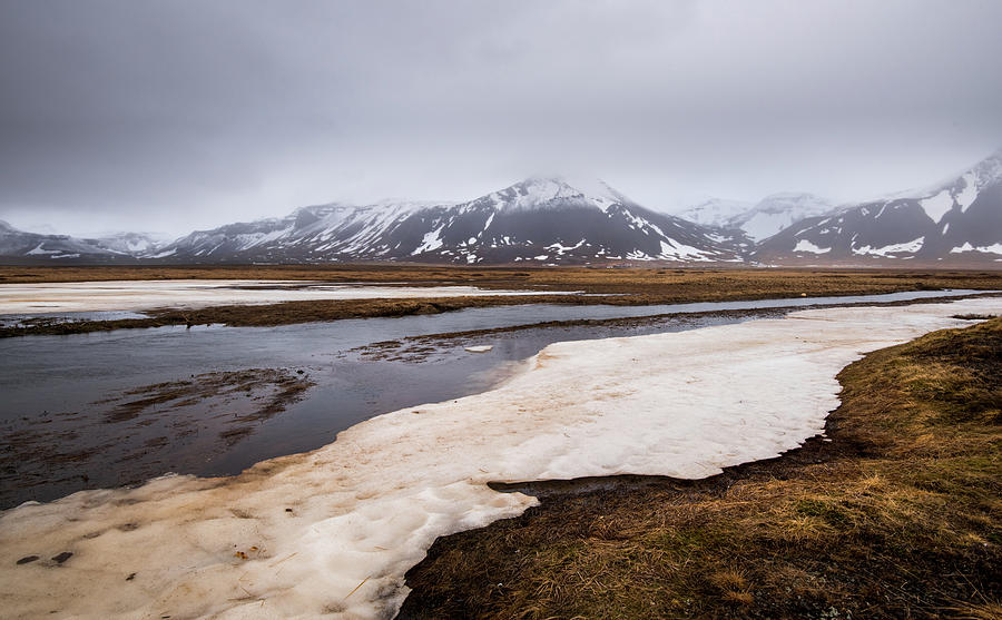 Meadow with snow and frozen lake and snowcapped mountains. Iceland Photograph by Michalakis Ppalis