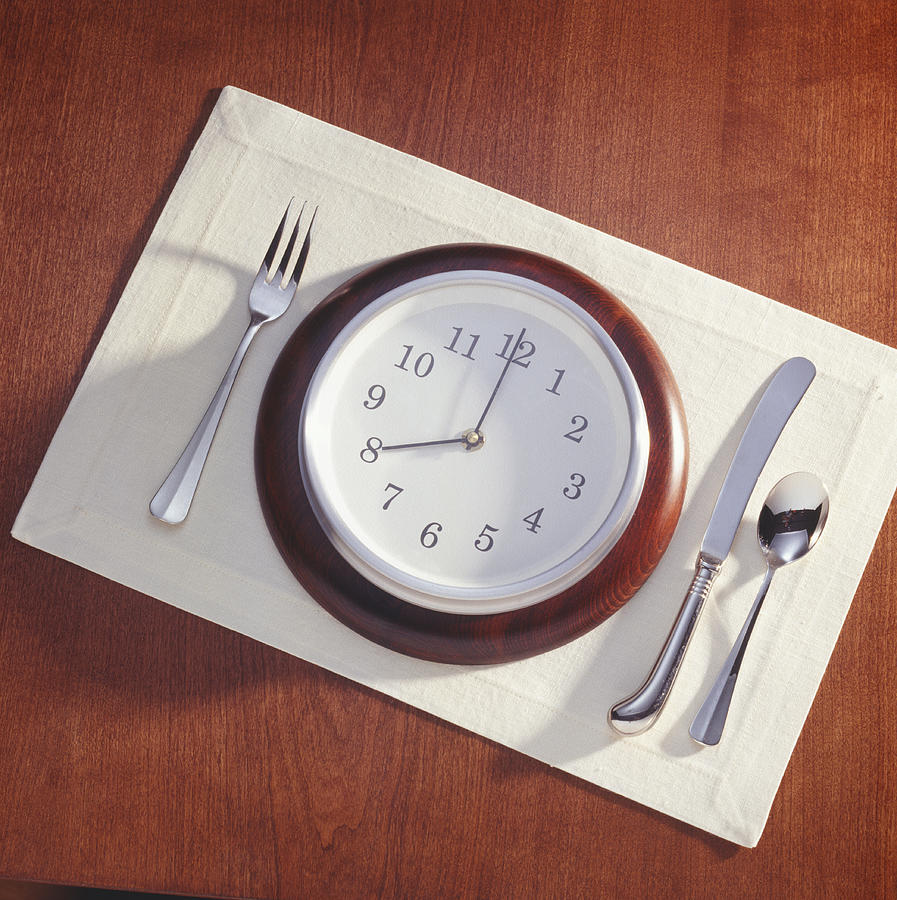Meal place setting with clock as plate Photograph by Photodisc