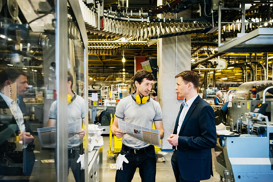 Mechanic and Manager talking in huge factory Photograph by TommL