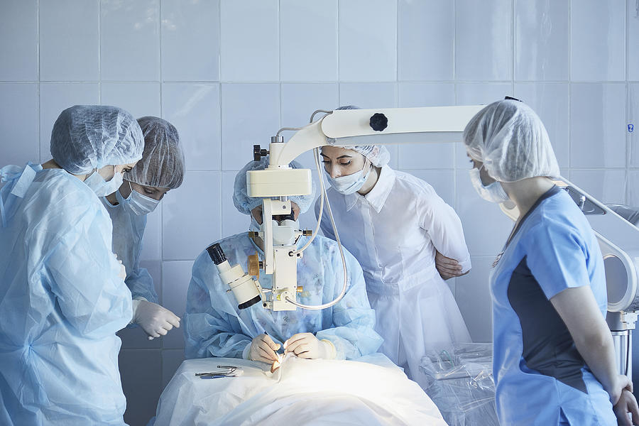 Medical team performing surgery on patient at hospital Photograph by Alexandr Sherstobitov