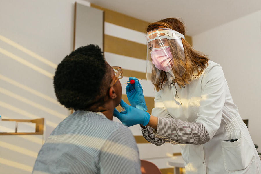 Medical worker testing black woman for possible coronavirus Infection Photograph by Dimensions