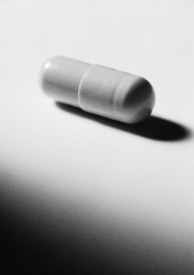 Medicine capsule, close-up, B&W Photograph by Laurent Hamels