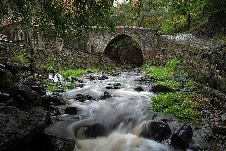 Medieval stoned bridge water flowing in the river. Photograph by Michalakis Ppalis