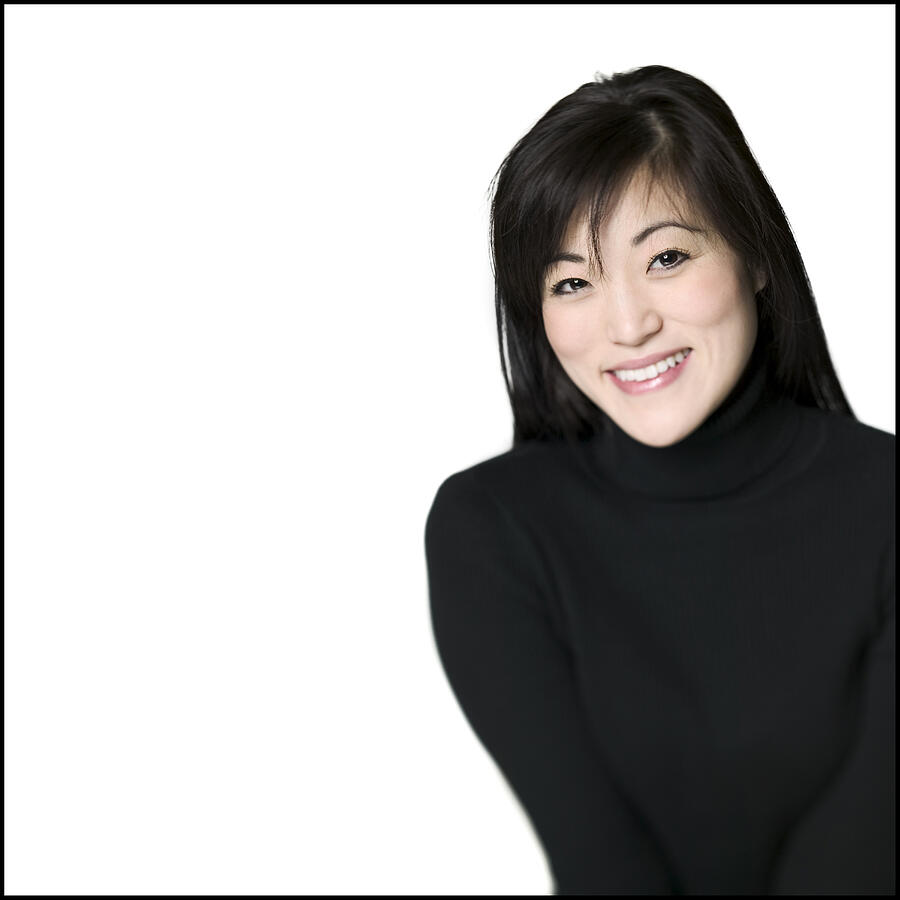 Medium Shot Of A Young Adult Woman In A Black Sweater As She Smiles Photograph by Photodisc