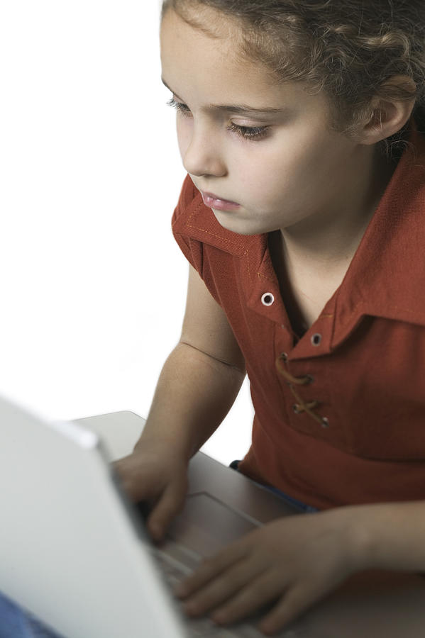 Medium Shot Of A Young Female Child As She Types On A Laptop Computer Photograph by Photodisc