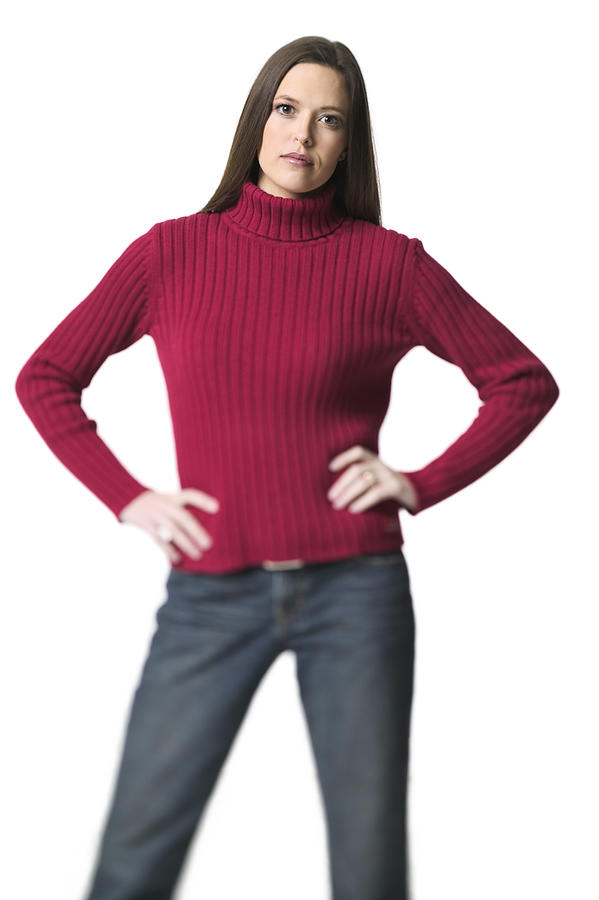 Medium Shot Of Young Adult Woman In Red Sweater Has Hands On Her Hips And Looks At The Camera Photograph by Photodisc