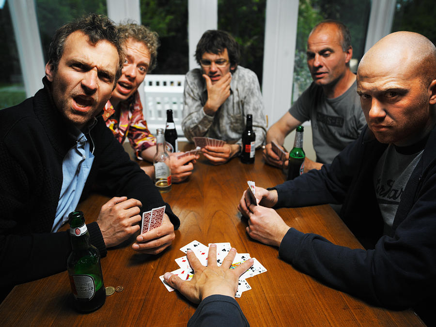 Men at table with drinks playing cards, portrait Photograph by Henrik Sorensen