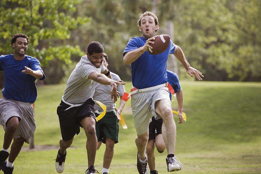 Men playing flag football together Photograph by Jupiterimages