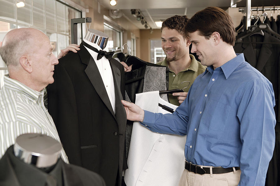 Men shopping for tuxedos Photograph by Comstock Images