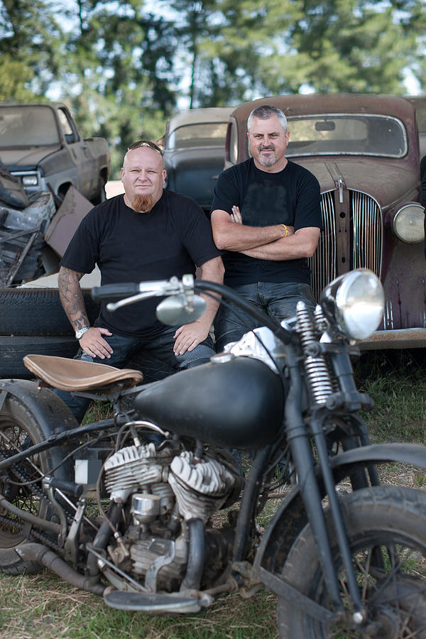 Men sitting with motorcycle Photograph by Image Source/Zero Creatives