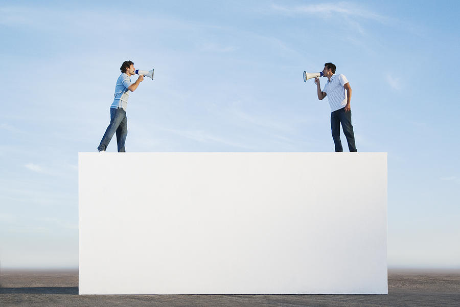 Men standing on wall outdoors with megaphones Photograph by Martin Barraud
