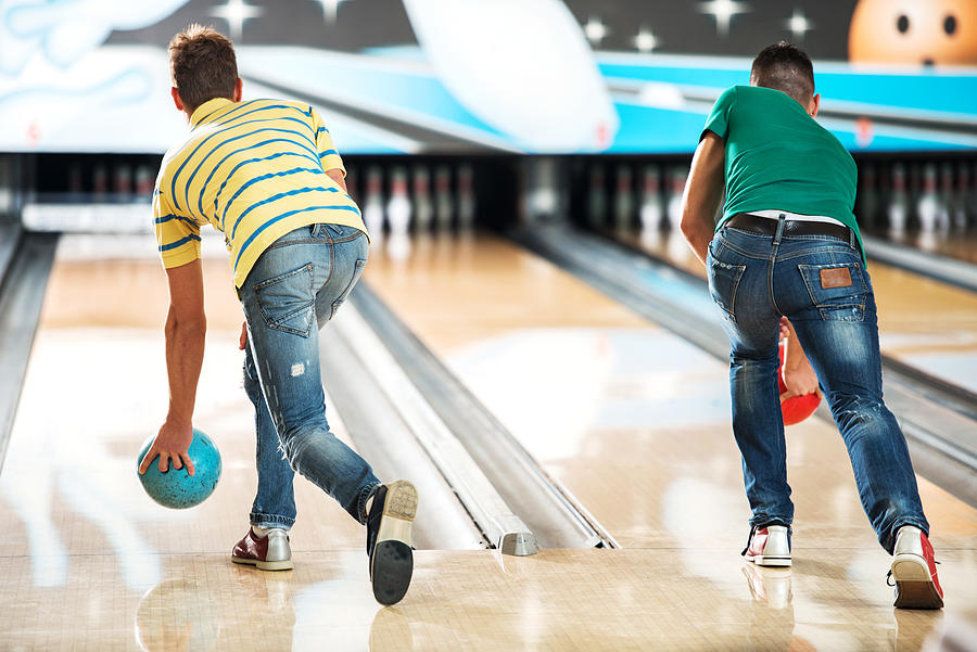 Men throwing a bowling ball. Photograph by Skynesher