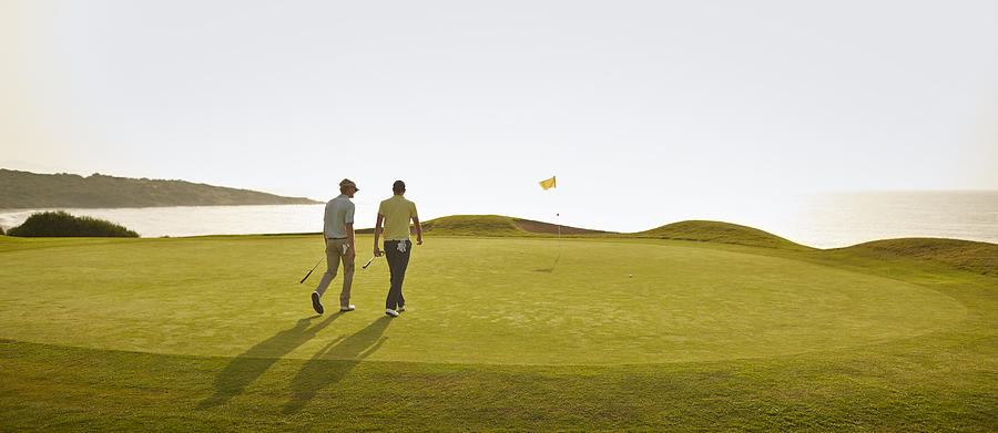 Men walking on golf course Photograph by Chris Ryan