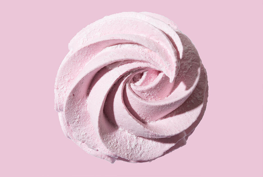 Meringue marshmallow zephyr on pink background. Trendy top view dessert image. Close-up of pink sweet homemade zephyr. Photograph by Yulia Naumenko
