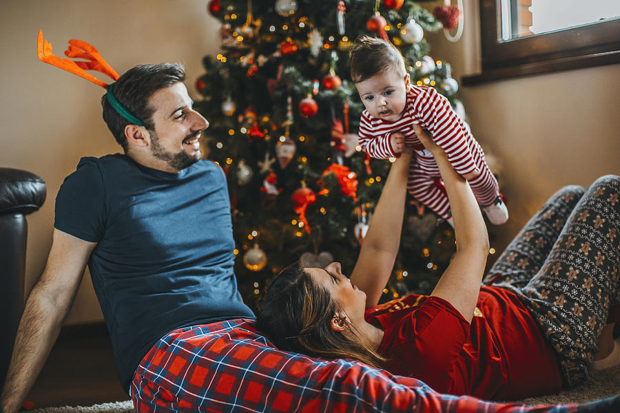 Merry Christmas! happy family mother father and child with gifts near tree Photograph by Obradovic