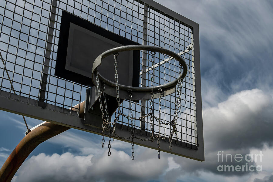 Metal Basketball Board And Ring With Chains In Front Of Sky With Heavy Clouds Photograph by Andreas Berthold