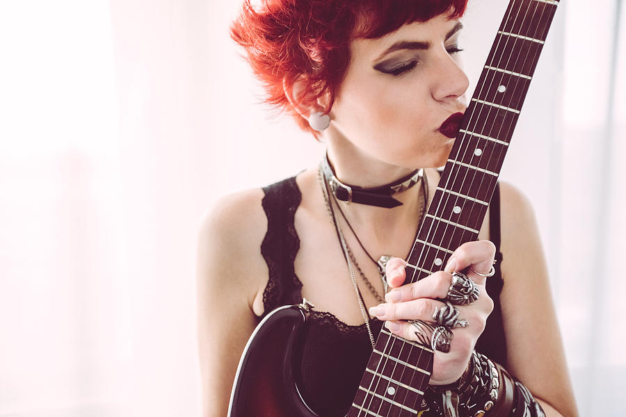 Metal girl posing and kissing a guitar Photograph by Urbazon