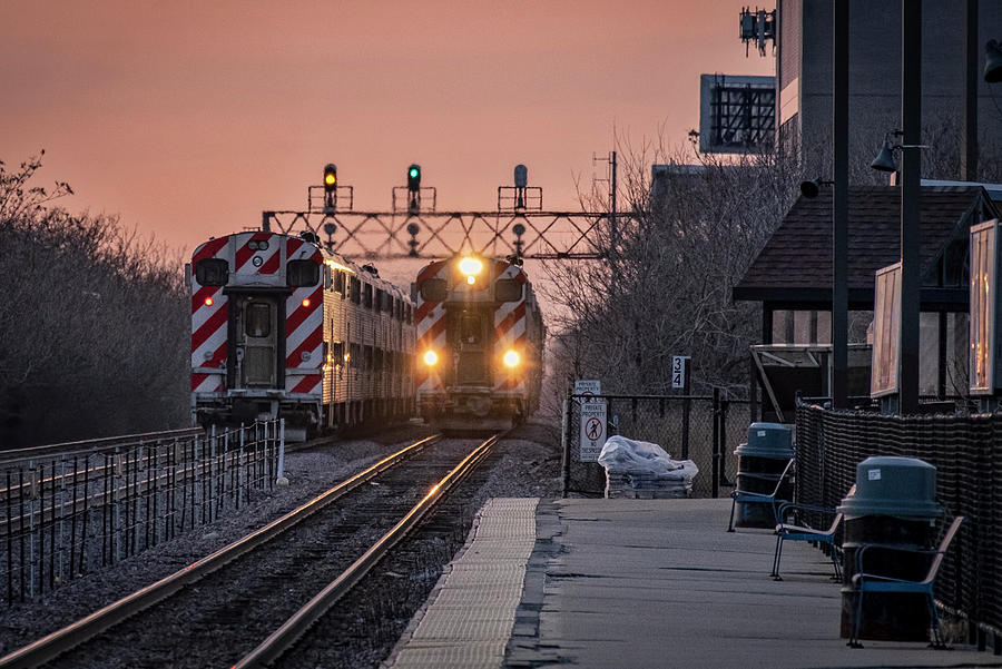 Metra trains pass each other at the Jefferson Park Metra Station Photograph by Jim Pearson