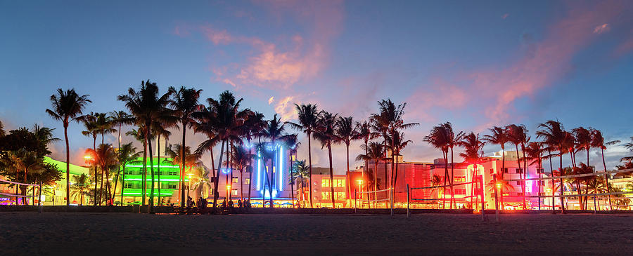Miami Beach Ocean Drive panorama with hotels and restaurants at sunset. City skyline with palm trees at night. Art deco nightlife on South beach Photograph by Maria Kray