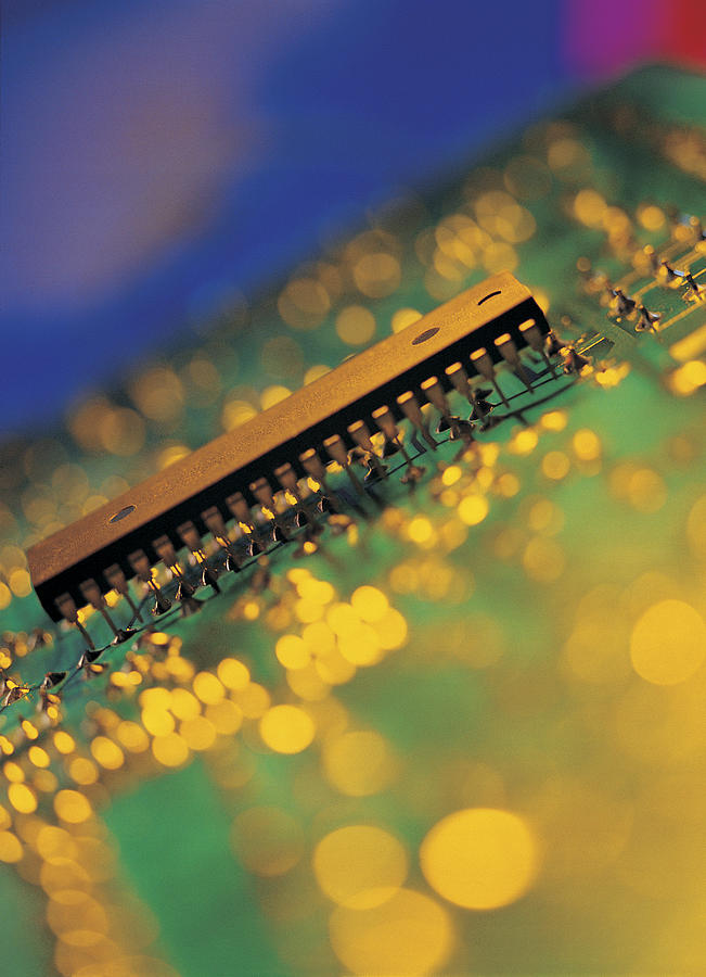 Micro-chip amid blurred points of golden light Photograph by Chris Knapton